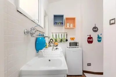 a bathroom with a sink and a small refrigerator at Roma MetroB Apartment in Rome