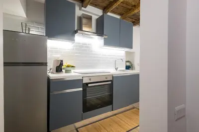 a kitchen with blue cabinets and a refrigerator at Boutique Atrium Pantheon in Rome