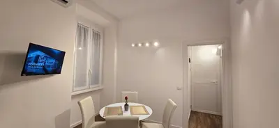 a white dining room with a table and chairs at Rooms And Comfort Apartment in Rome