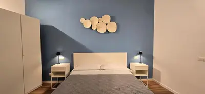 a bedroom with a bed and two lights on the wall at Rooms And Comfort Apartment in Rome