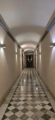 an empty hallway with a checkered floor and lights at Rooms And Comfort Apartment in Rome