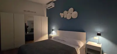 a bedroom with a bed and two lights on the wall at Rooms And Comfort Apartment in Rome