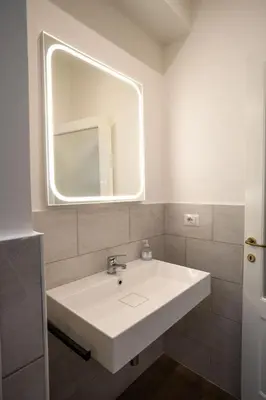 a bathroom with a white sink and a mirror at VT Cola di Rienzo Elegant Suites in Rome