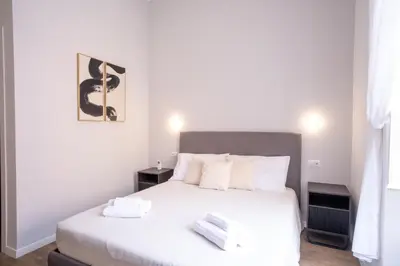 a bedroom with a white bed with two towels on it at VT Cola di Rienzo Elegant Suites in Rome