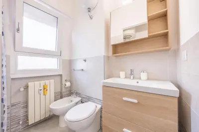a bathroom with a toilet and a sink and a window at vaticanloft for you in Rome