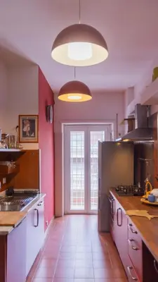 a large kitchen with pink walls and a large window at casabella cipro musei vaticani in Rome