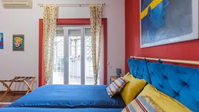 a bedroom with a blue bed and a red wall at casabella cipro musei vaticani in Rome