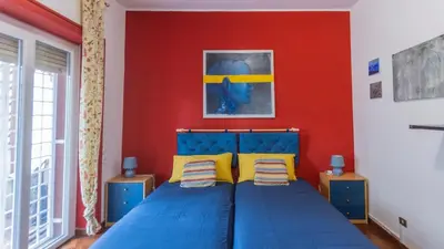 a bedroom with a blue bed with a red wall at casabella cipro musei vaticani in Rome