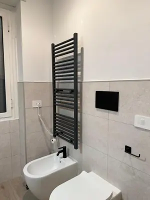 a bathroom with a white toilet and a sink at Vita Lux Vatican Suites in Rome