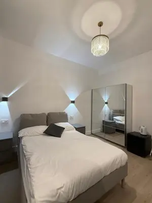 a bedroom with a large white bed with a mirror at Vita Lux Vatican Suites in Rome