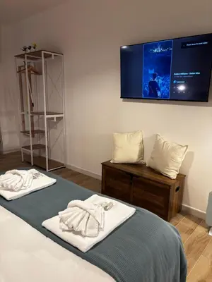 a bedroom with a bed with a tv on the wall at The Hatters Inn in Rome