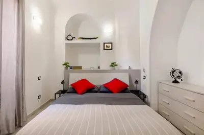 a bedroom with a bed with two red pillows at La Casetta Sabelli In the center of Rome in Rome