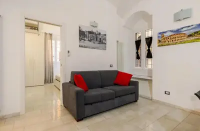 a living room with a couch with two red pillows at La Casetta Sabelli In the center of Rome in Rome