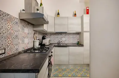 a kitchen with white cabinets and a stove top oven at La Casetta Sabelli In the center of Rome in Rome