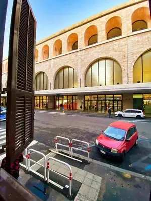 a red car parked in a parking lot in front of a building at Cialdini 13 Roma in Rome
