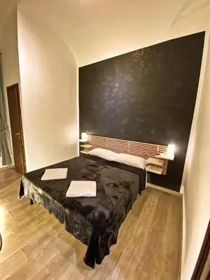 a room with a bed with a black table at Cialdini 13 Roma in Rome