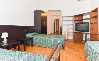 a blue room with two beds and a mirror at Ogbay Backpackers Haven in Rome