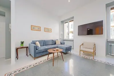 a living room with a blue couch and a tv at YCH-Spaceful apartment near Vatican in Rome