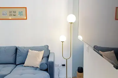 a living room with a blue couch and a floor lamp at YCH-Spaceful apartment near Vatican in Rome