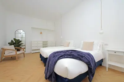 two beds in a room with white walls and wooden floors at YCH-Spaceful apartment near Vatican in Rome