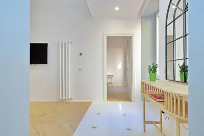 a living room with white walls and a table at YCH-Spaceful apartment near Vatican in Rome