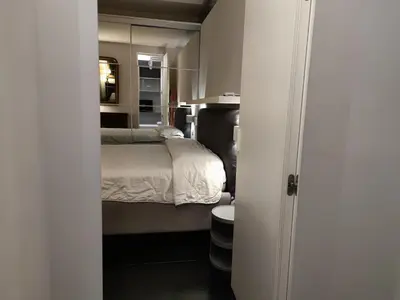 a small bedroom with a bed and a mirror at Banchi Nuovi Ventuno in Rome