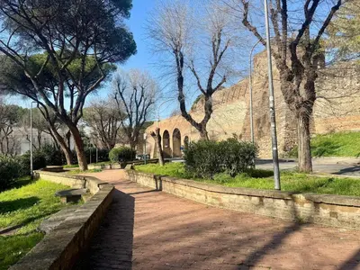 a park with a bench and trees and a building at Caracalla Loft in Rome