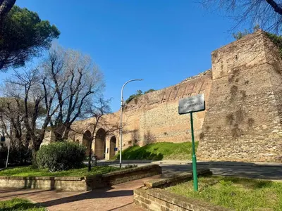 a large stone wall with a sign next to it at Caracalla Loft in Rome