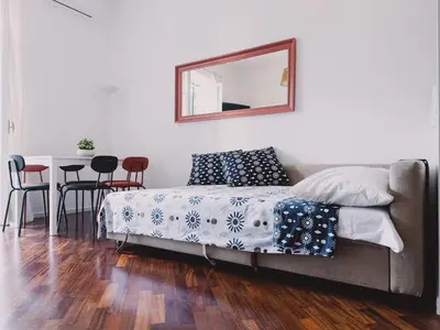 a bedroom with a bed with a mirror and a table at Casetta in Rome