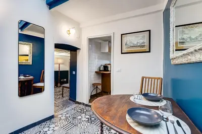 a dining room with a wooden table and blue walls at Vivilo Collection - Macelli Spanish Steps Apartment in Rome