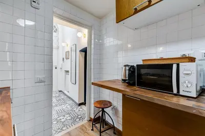 a kitchen with a microwave on a counter with a stool at Vivilo Collection - Macelli Spanish Steps Apartment in Rome