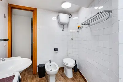 a white bathroom with a toilet and a sink at Vivilo Collection - Macelli Spanish Steps Apartment in Rome
