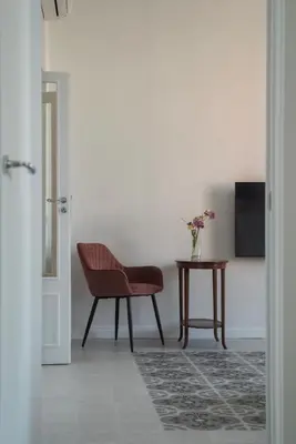 a living room with a chair and a table at Dante's View - Pretty Homes in Rome