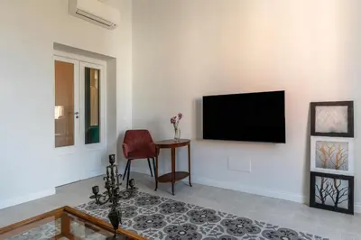 a living room with a flat screen tv on a wall at Dante's View - Pretty Homes in Rome