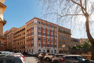 a large brick building with cars parked in a parking lot at Dante's View - Pretty Homes in Rome