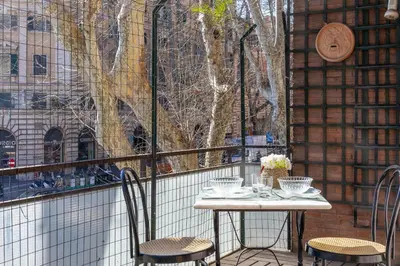 a table and chairs on a balcony with a window at Amazing Apartment Trastevere in Rome