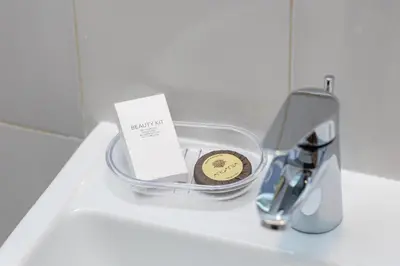 a basket on a sink with a coin and a faucet at Amazing Apartment Trastevere in Rome
