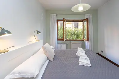 a bedroom with a bed with white pillows and a window at Amazing Apartment Trastevere in Rome