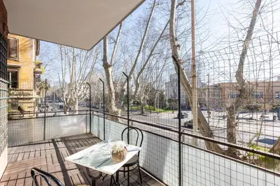 a balcony with a table and chairs and a large window at Amazing Apartment Trastevere in Rome