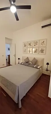 a bedroom with a large bed and a ceiling fan at Casa Romantica in Rome
