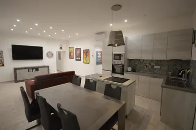 a kitchen and living room with a table and chairs at San Remo Apartment in Rome