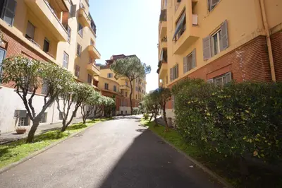 an empty street in a city with buildings at San Remo Apartment in Rome