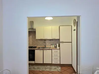 a kitchen with white cabinets and a white refrigerator at Candia 66 at the Vatican Museums in Rome