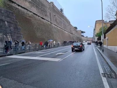 a car driving down a street next to a wall at Candia 66 at the Vatican Museums in Rome