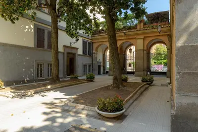 an empty courtyard with trees and a building at Salotto19 - Villa Borghese in Rome