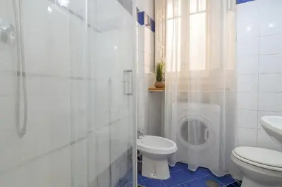 a white bathroom with a toilet and a shower at Salotto19 - Villa Borghese in Rome