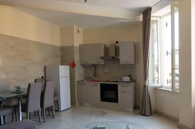 a kitchen with a refrigerator and a table with chairs at Sistina Apartment in Rome