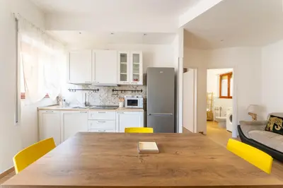a kitchen with a wooden table and yellow chairs at Domus Citro, Cozy Flat in District Prenestina in Rome