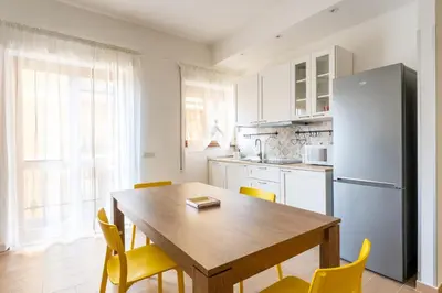 a kitchen with a wooden table and a refrigerator at Domus Citro, Cozy Flat in District Prenestina in Rome