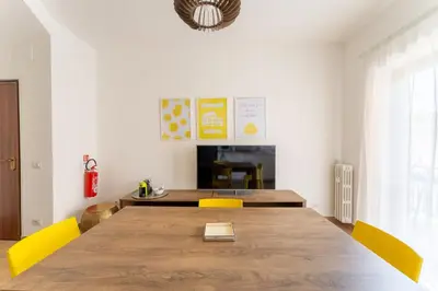 a dining room with a large wooden table and yellow chairs at Domus Citro, Cozy Flat in District Prenestina in Rome